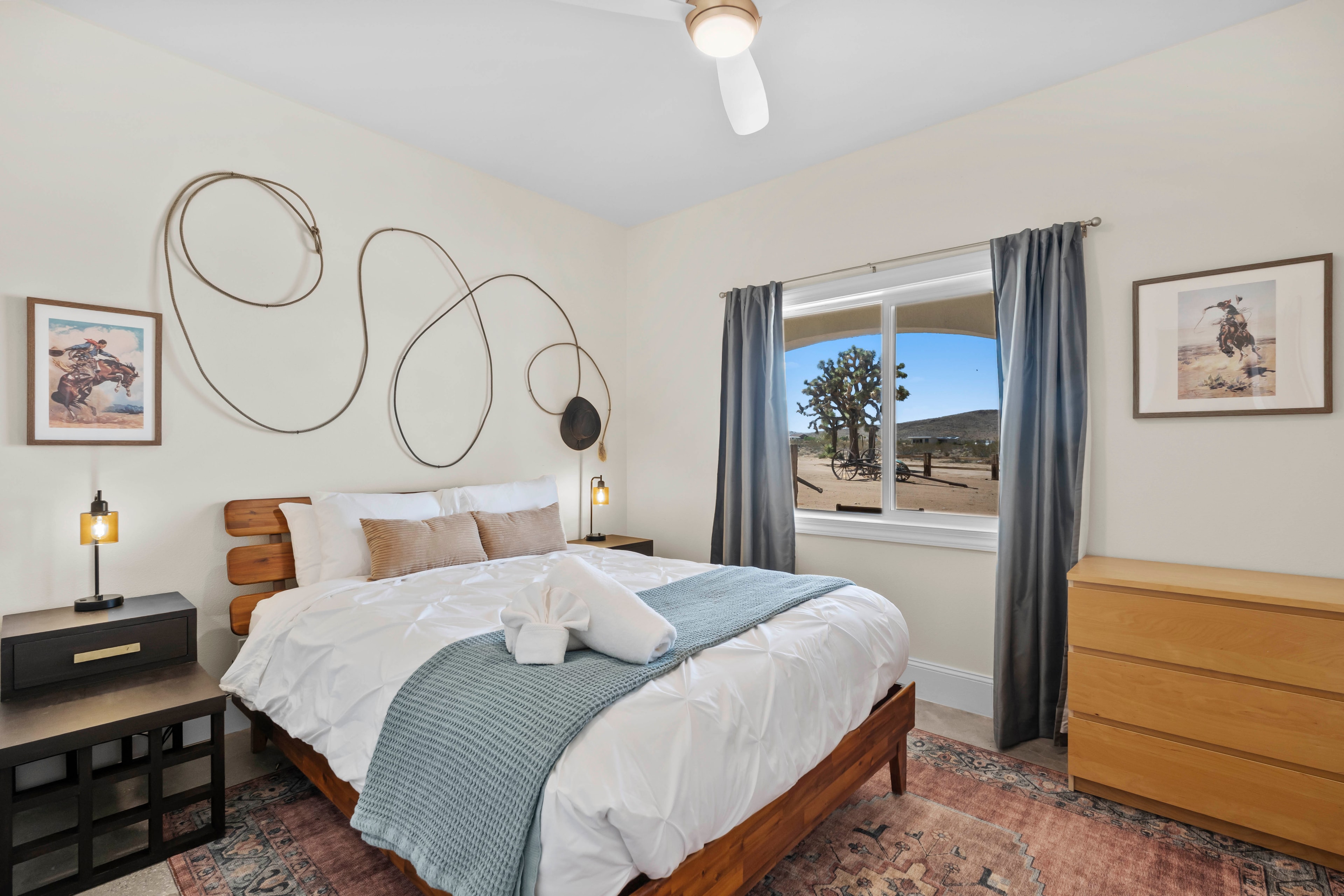 Guest Room Two with queen bed and lasso wall art at Waning Moon Ranch